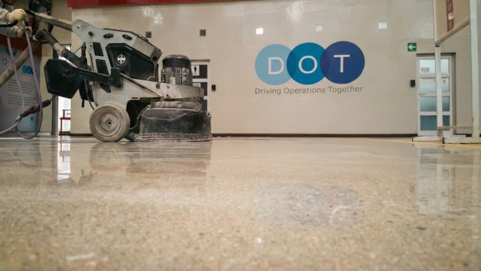 Piso de hormigón lapidado con acabado similar al granito, obra de Comar Pinturas
