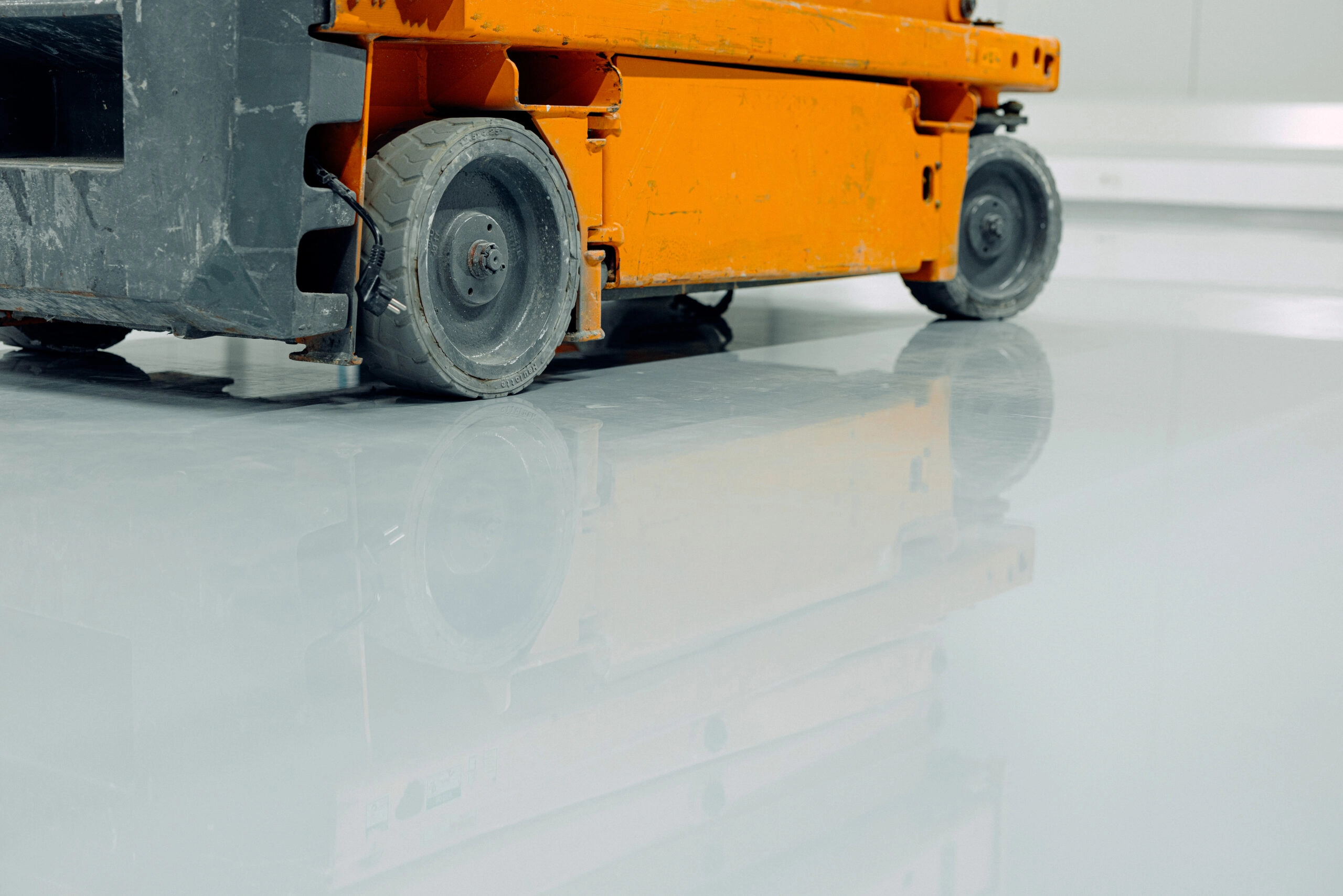 orange scissor platform in close-up view, newly epoxy floor resin